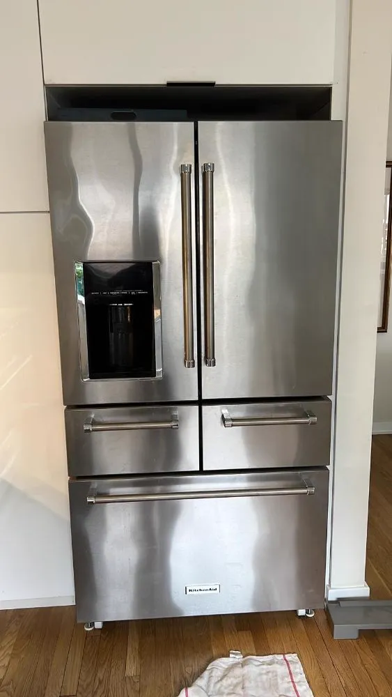 Stainless French-door refrigerator on a service call